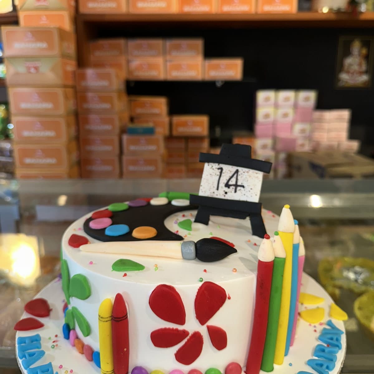 Artist palette birthday cake with fondant paint brushes and colour splashes