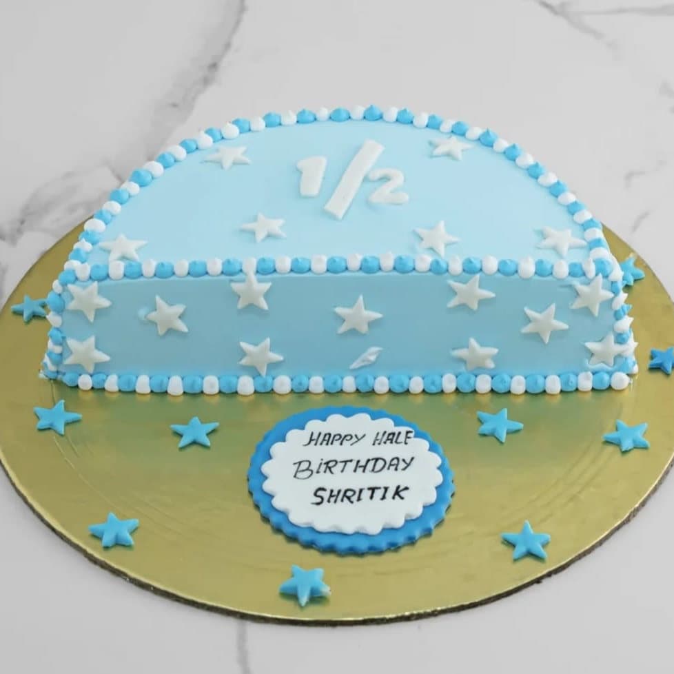 Blue half birthday cake with white stars and a one half topper