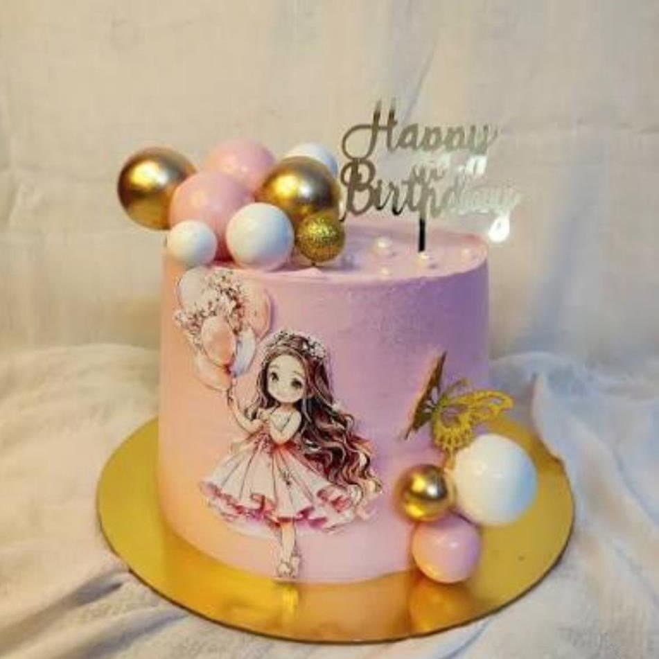 Pastel ombre birthday cake with gold and pink balls and a princess figurine