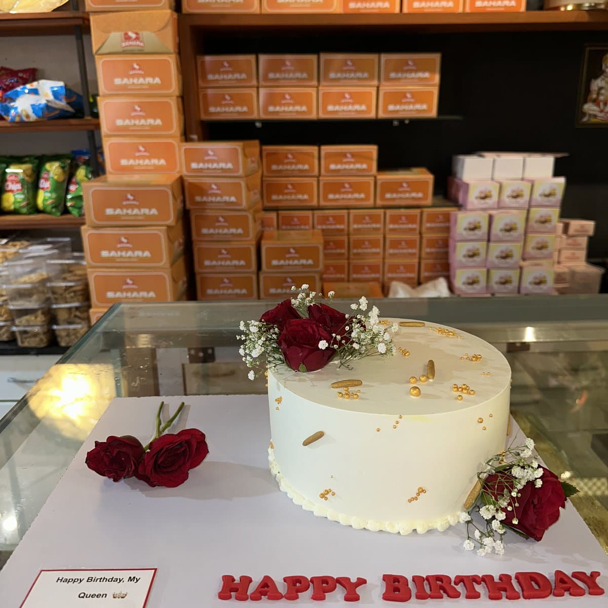 Ivory cake with gold flecks and fresh red roses reading Happy Birthday My Love
